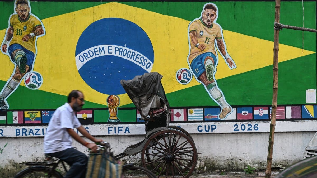 Un ciclista pasa junto a un grafiti con las imágenes del futbolista brasileño Neymar