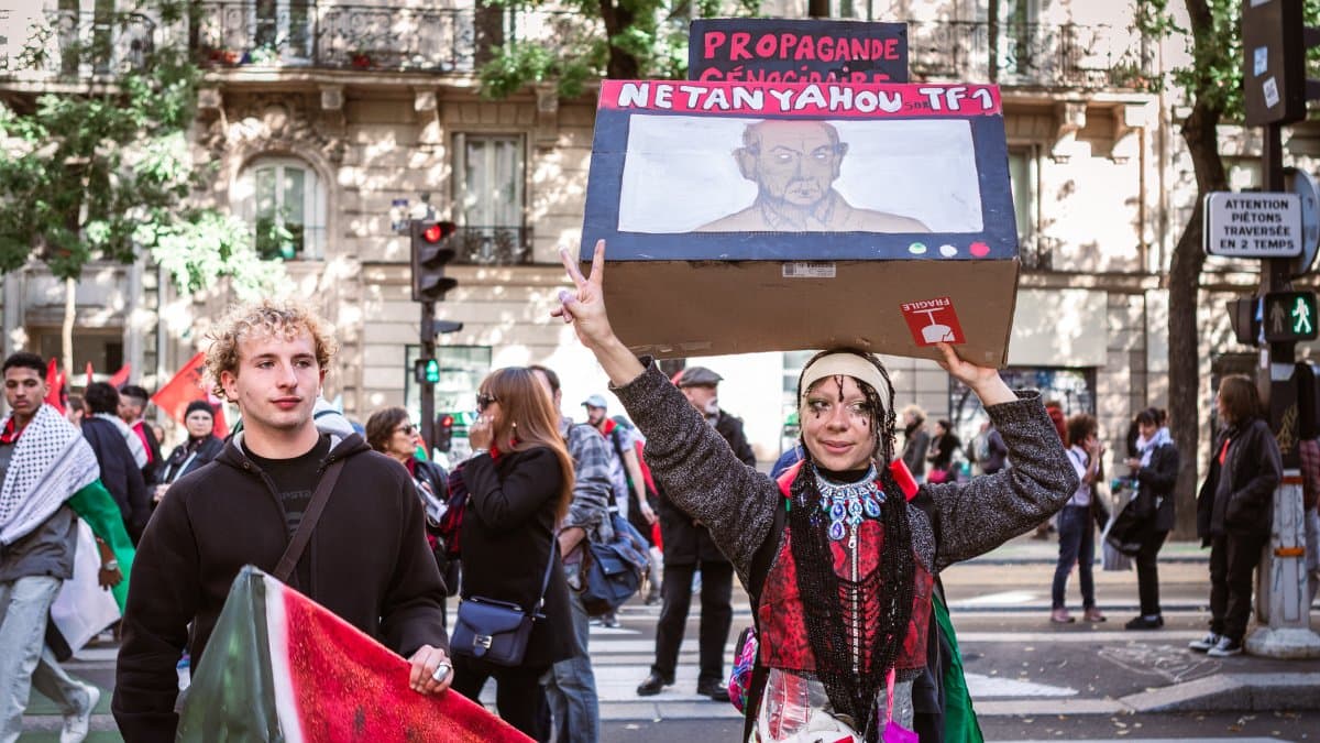Manifestantes con una pancarta y un cartel durante una manifestación en apoyo a Palestina en París
