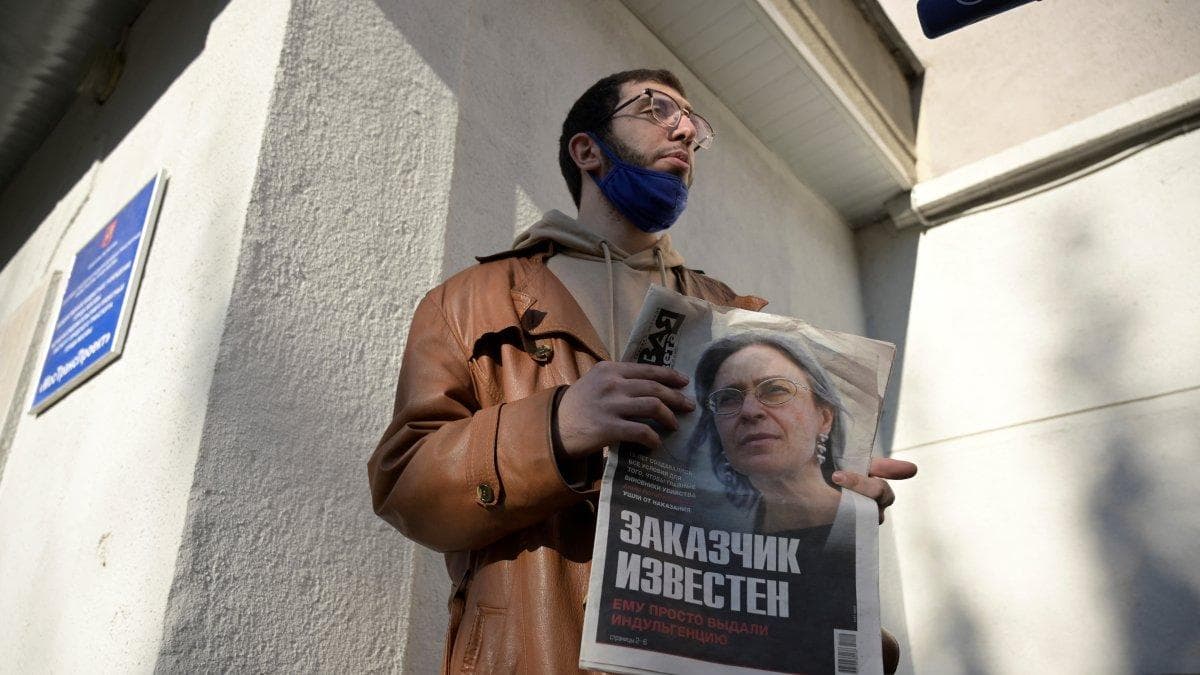 Un hombre sostiene un periódico en el que aparece una foto de la periodista de investigación Anna Politkovskaya