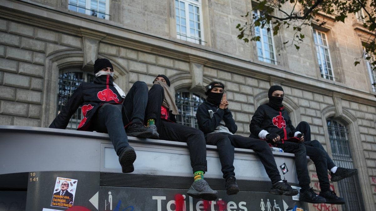 Manifestantes se sientan en el tejado de un baño público en París